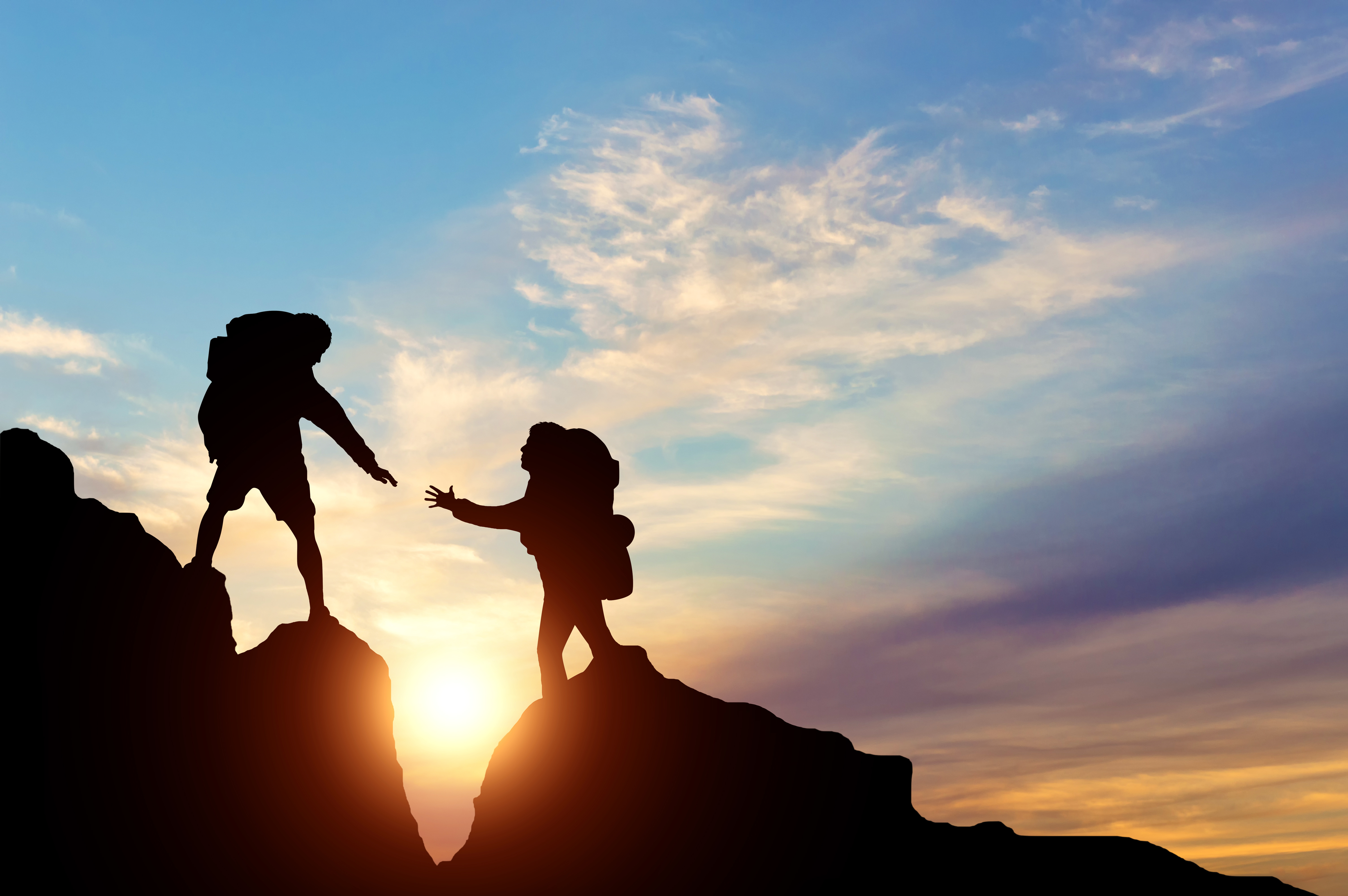 Climber reaches out to his partner by helping each other. concept of teamwork